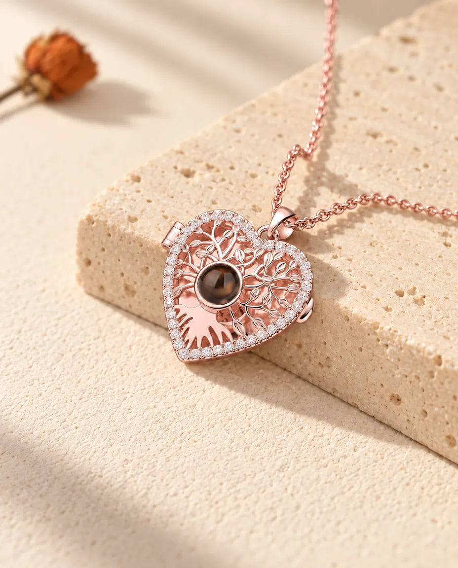 Collier médaillon cœur arbre de vie couleur or rose drapé sur un bloc de travertin