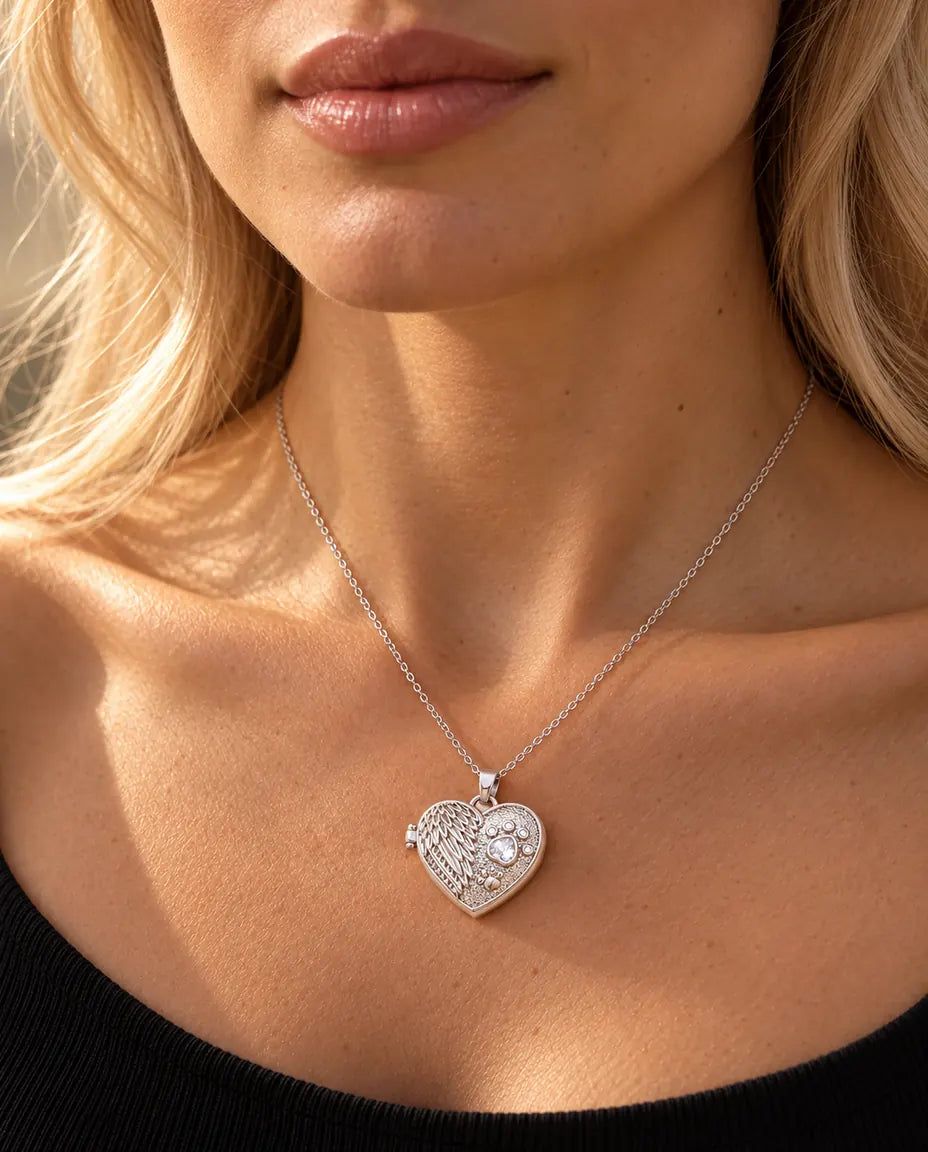 Femme en haut en maille noire portant le collier médaillon photo cœur aile d'ange et patte argenté