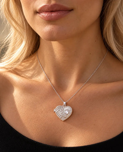 Femme en haut en maille noire portant le collier médaillon photo cœur aile d'ange et patte argenté