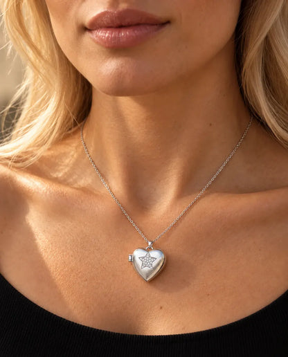 Femme en haut en maille noire portant le médaillon photo cœur étoile en zircons argenté