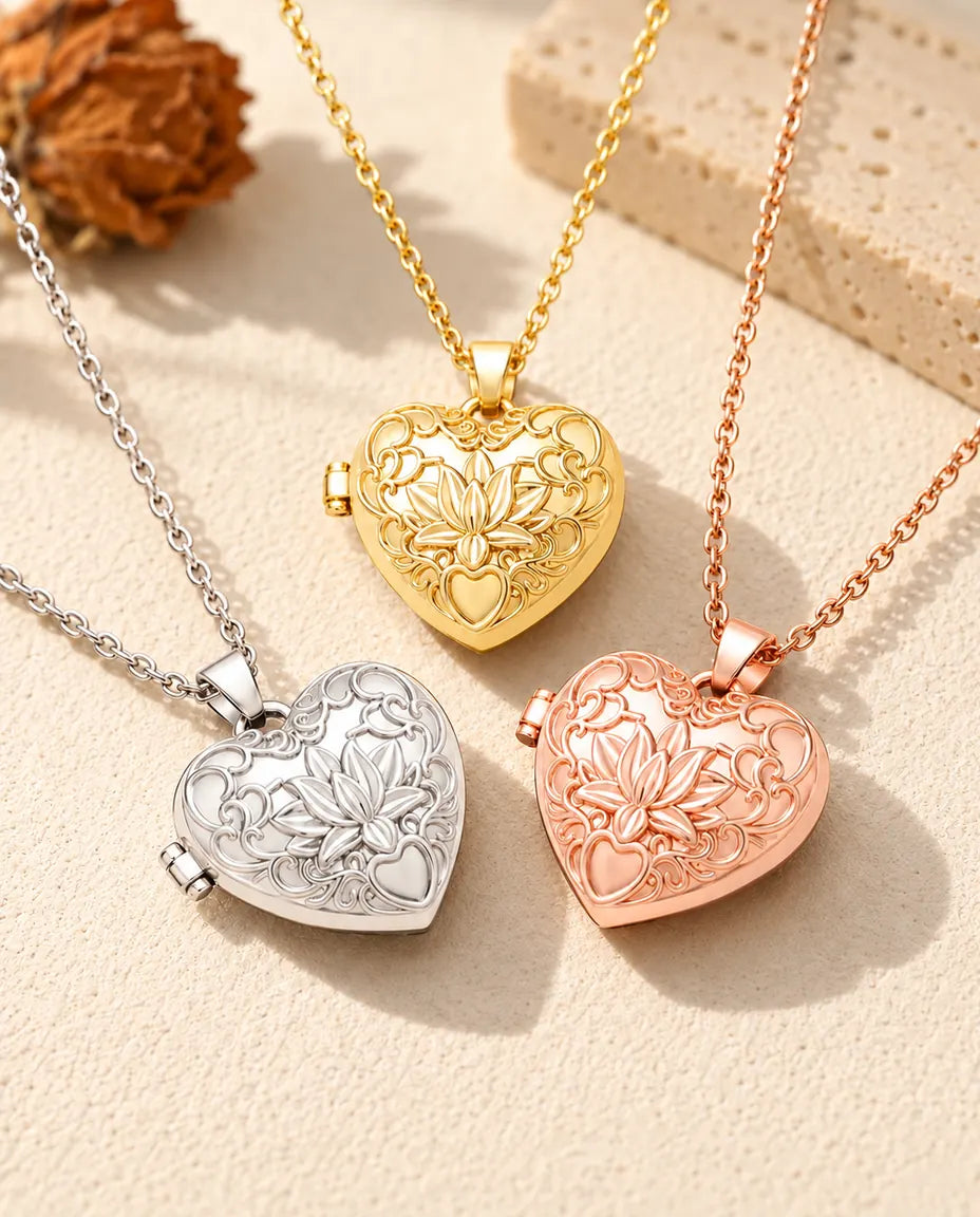 Les trois couleurs du collier médaillon photo cœur fleur de lotus disposées sur du plâtre