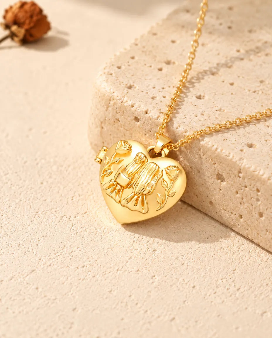 Collier médaillon photo cœur sœurs doré posé sur un bloc de travertin