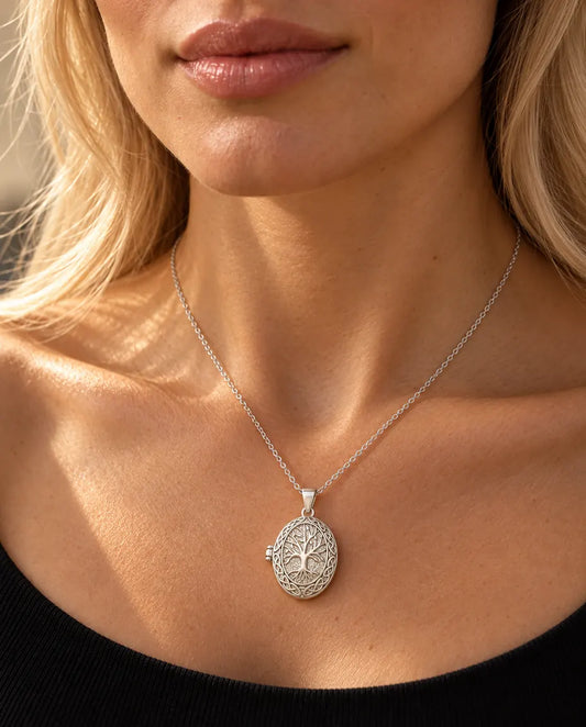 Femme en haut en maille noir portant le collier médaillon photo arbre de vie argenté