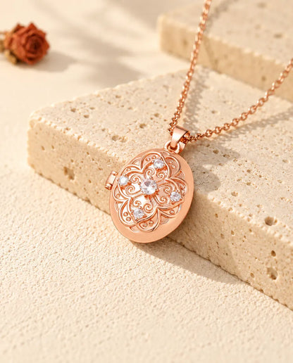 Médaillon photo ovale couleur or rose à fleur de zircons posé sur du travertin
