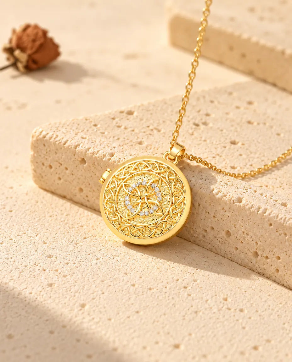 Collier médaillon photo rond nœud celtique doré posé sur un bloc de travertin
