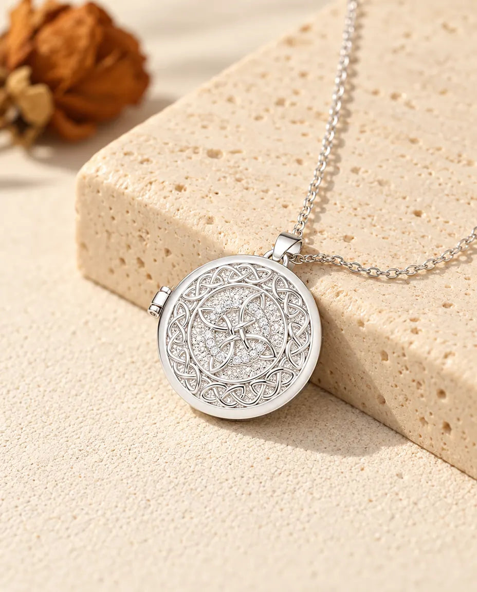 Collier personnalisé médaillon photo rond nœud celtique, couleur argentée, posé contre un bloc de travertin