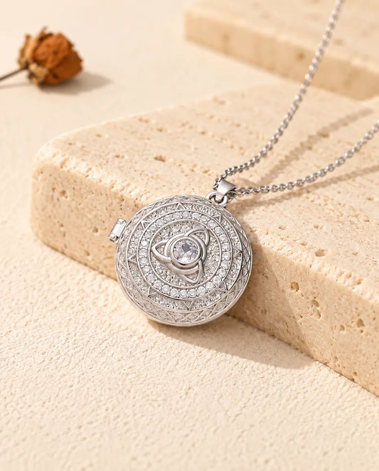 Collier médaillon photo rond personnalisé à nœud triquetra argenté et zircons posé contre un bloc de travertin