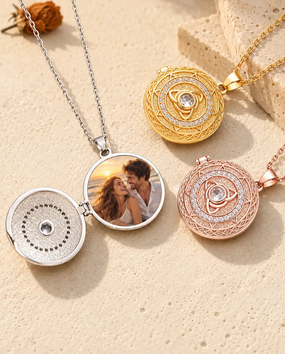 Médaillon triquetra argenté ouvert sur une photo de couple à la plage, à côté des versions dorée et couleur or rose fermées