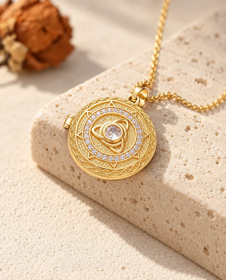 Collier médaillon rond triquetra doré avec pierre centrale posé sur le bord d'un bloc de travertin