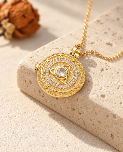 Collier médaillon rond triquetra doré avec pierre centrale posé sur le bord d'un bloc de travertin
