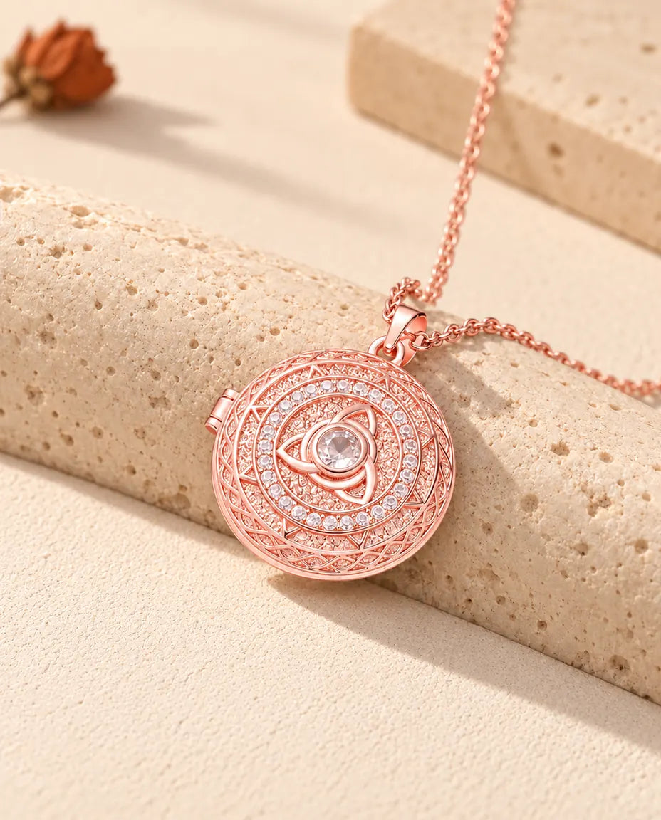 Médaillon photo triquetra couleur or rose avec cercle de zircons posé sur du travertin