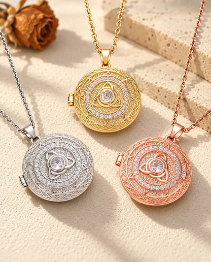 Le collier médaillon photo triquetra dans ses trois couleurs disposé sur du plâtre