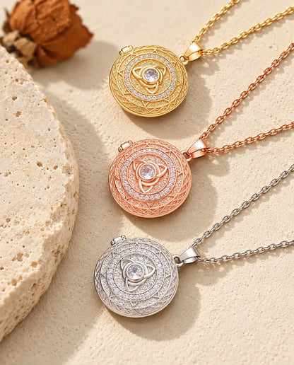 Médaillons triquetra doré, couleur or rose et argenté superposés près d'une dalle de travertin