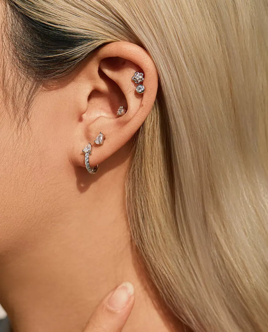 Puces d’Oreilles Moissanite Poire à Deux Griffes en Argent 925 - portée par un mannequin, main posée sur le cou
