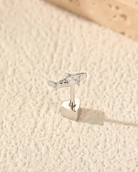 Puces d’Oreilles Requin en Argent 925 et Moissanite - debout sur son fermoir en forme de cœur, sur une surface claire texturée